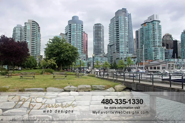 Coal Harbour waterfront in Vancouver with glass condo towers, park benches on the green, and boats at the marina boardwalk